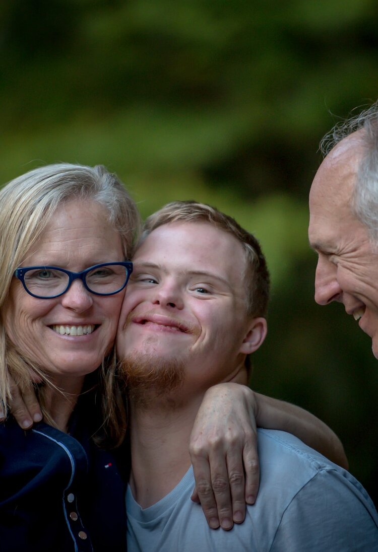 Sohn mit Behinderung und seinen Eltern umarmen sich.  | © Unsplash