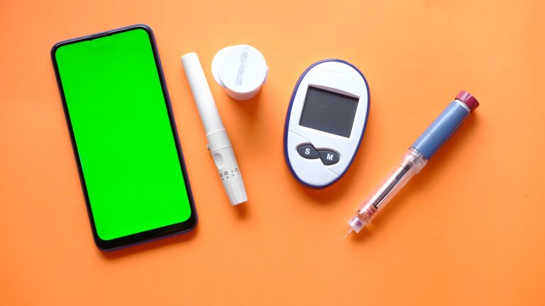 Smartphone und verschiedene Diabetes-Hilfsmittel | © Unsplash
