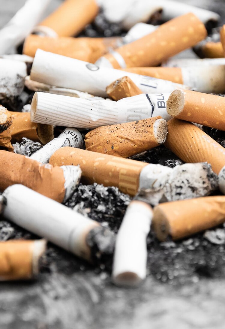 Diverse gerauchte Zigaretten liegen am Boden. | © Unsplash