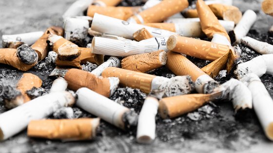 Diverse gerauchte Zigaretten liegen am Boden. | © Unsplash
