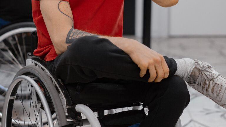 Ein Mann in Jogginghosen im Rollstuhl. Der Kopf des Mannes ist im Bild nicht sichtbar. | © pexels