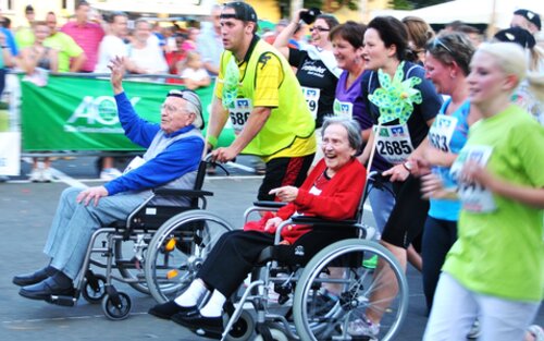 Firmenlauf mit zwei älteren Menschen im Rollstuhl, die von den Läufern gestossen werden. | © pixabay