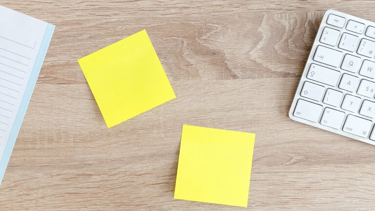 Zwei gelbe Post-it Notizzettel liegen auf einem Schreibtisch neben einer Tastatur. | © pexels