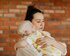 Eine Mutter hält stehend ihr Baby im Arm. | © Pexels / Karolina Grabowska