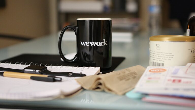 Arbeitsplatz mit Tasse "wework".  | © Unsplash