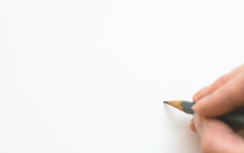 Eine Hand mit einem Bleistift über einem unbeschriebenen weissen Blatt Papier. | © pexels