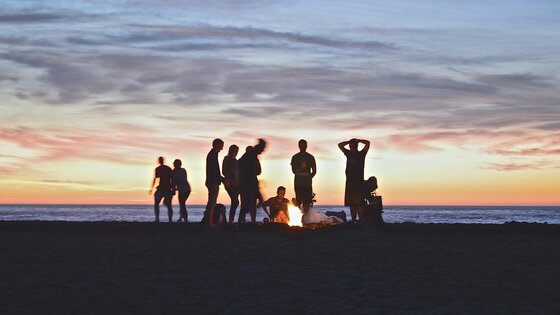 Eine Gruppe von Menschen um ein Lagerfeuer. 
