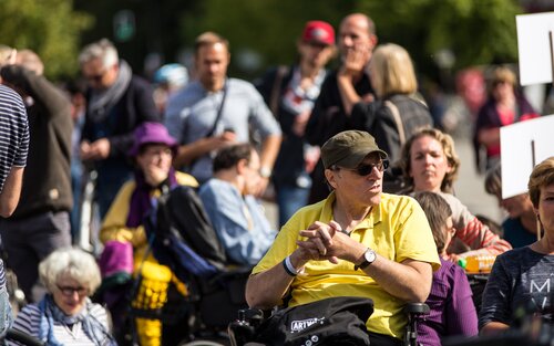 Mehrere Menschen mit Behinderungen draussen, an einer Art Protest. | © Gesellschaftsbilder, Jörg Farys