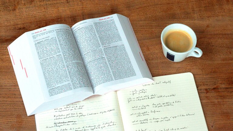 Un manuel de droit, un cahier et un café | © pixabay