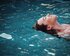 junge Frau, die auf dem Rücken auf dem Wasser treibt | © unsplash