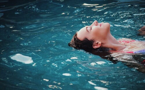junge Frau, die auf dem Rücken auf dem Wasser treibt | © unsplash