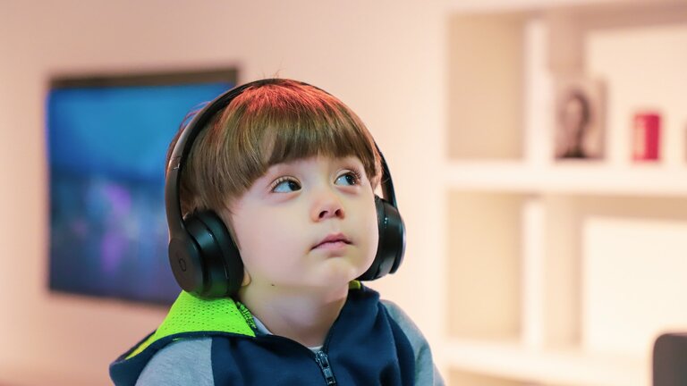 Kind, das Musik auf Kopfhörern hört | © unsplash