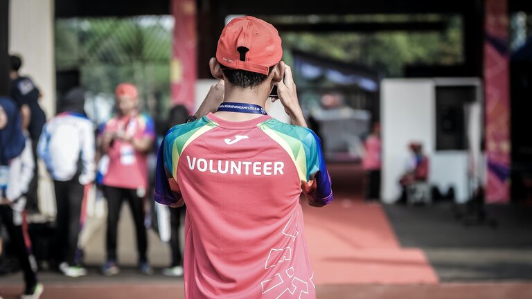 Foto eines Mannes mit rotem Shirt, auf dem "Volunteer" steht. | © unsplash