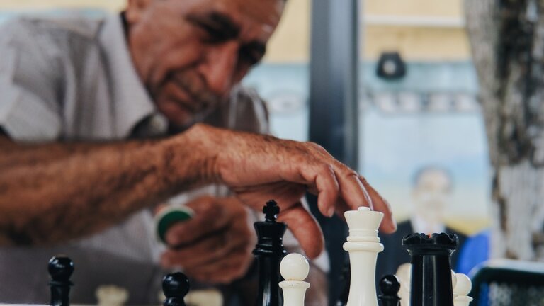 Foto eines älteren Mannes, der Schach spielt. | © unsplash