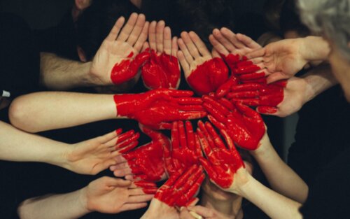 Rotes Herz, das auf mehrere Handflächen gemalt ist. | © unsplash
