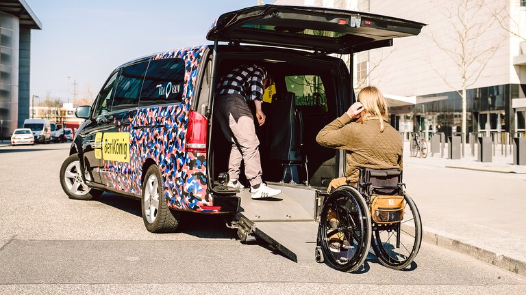 Un homme à mobilité réduite est assisté par son conducteur | © gesellschaftsbilder.de/