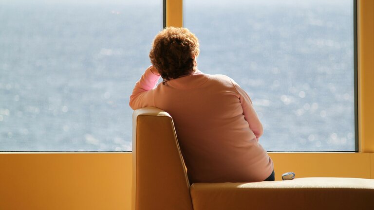 Une femme regarde l'océan à travers une fenêtre | © pixabay