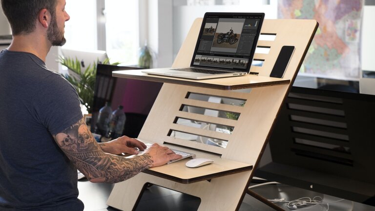 Homme travaillant sur un ordinateur à un bureau debout  | © unsplash