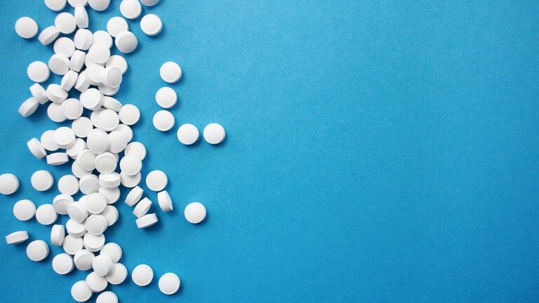 Foto von weissen Tabletten auf blauem Grund. | © unsplash