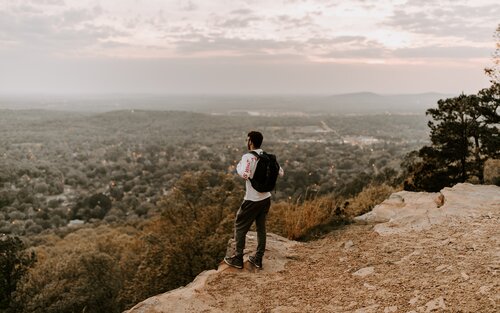 Ein Mann steht auf einem Berg und schaut hinab. | © unsplash