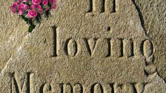 Ein Grabstein mit Blumen darauf. | © Pixabay