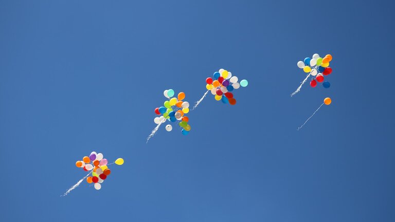 Ein blauer Himmel, an dem viele Ballone zu sehen sind. | © Unsplash