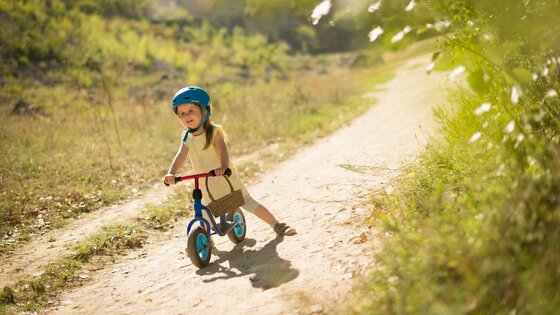 Ein lächelndes Mädchen auf einem Fahrrad. | © Unsplash