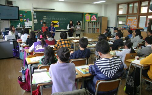 Eine Schulklasse, von hinten fotografiert, im Vordergrund stehen Lehrpersonen an einer Tafel. | © pixabay