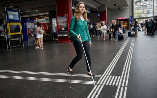 Eine Frau mit Blindenstock am Bahnhof. | © SBB CFF FFS/Flavia Trachsel