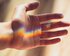 Ausgestreckte Hand, die durch eine Scheibe in Regenbogenfarben beschienen wird. | © pexels
