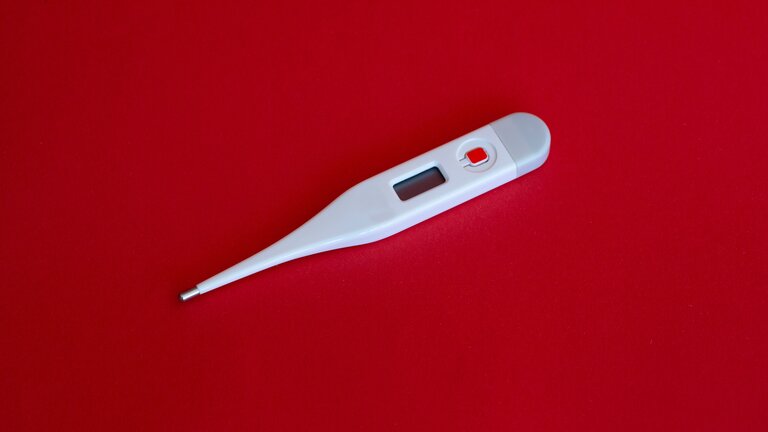 Ein Thermometer vor rotem Hintergrund. | © unsplash