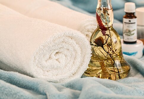 Ein Handtuch und eine Flasche Massageöl | © pixabay