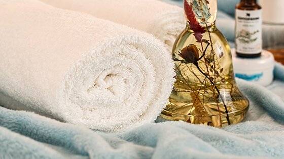Une serviette et une bouteille d'huile de massage | © pixabay